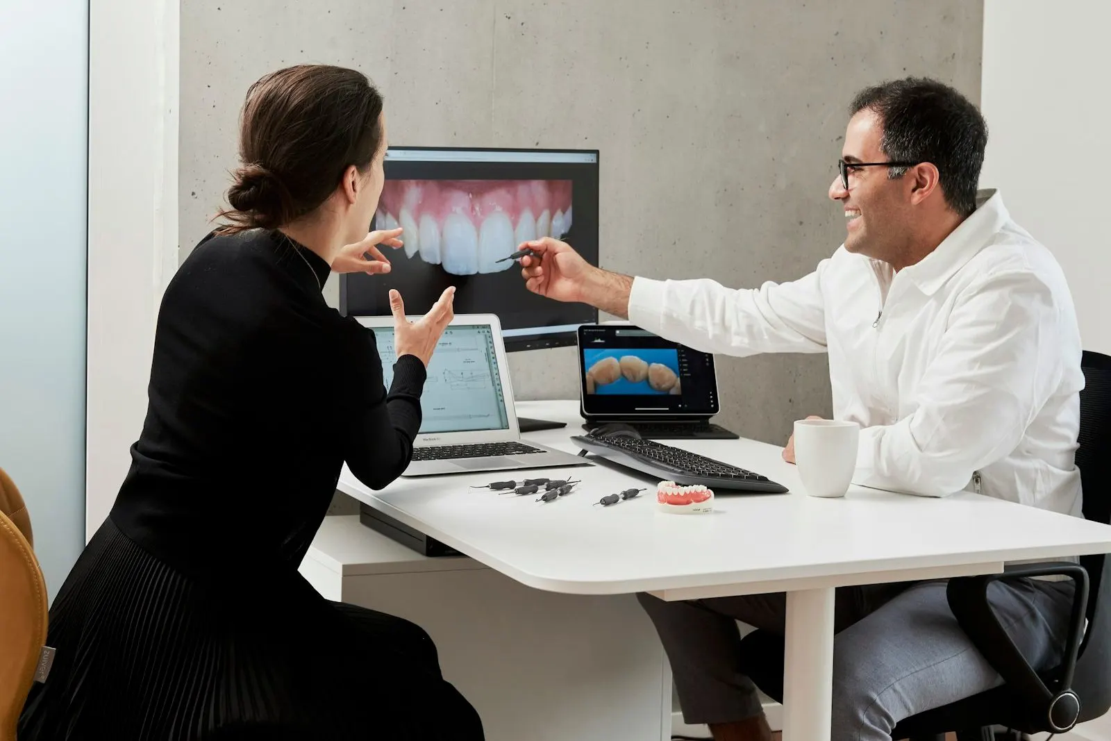 Profesional explicando una radiografía al paciente en pantalla